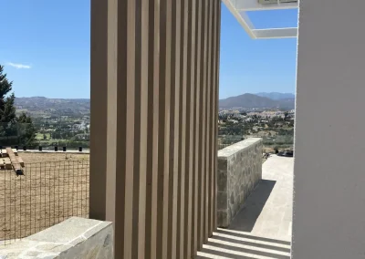 Celosía de lamas verticales de madera tecnológica en una terraza con vistas