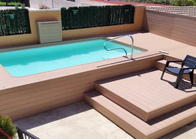 Piscina elevada con tarima perimetral y escalones de madera tecnológica en Cuenca