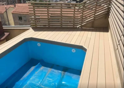 iscina en una terraza de Barcelona con tarima perimetral y celosía de lamas de madera tecnológica clara