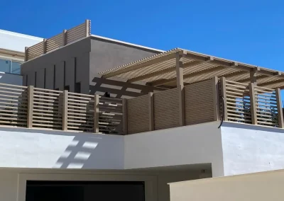 Valla de ocultación y pérgola de madera tecnológica en la terraza de una vivienda